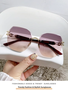 Primer plano de gafas de sol sin montura degradado morado con bisagras doradas