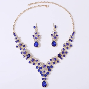 Close-up of gold-plated V-shape bridal necklace set with deep blue teardrop crystals