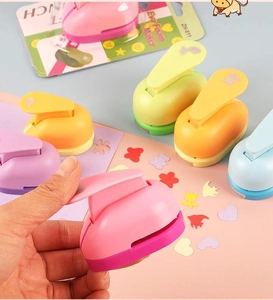 Close-up of a 1-inch colorful craft paper punch showing cut-out heart and butterfly shapes