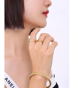 Detail shot of golden nail design open rings and woven texture bracelet on model