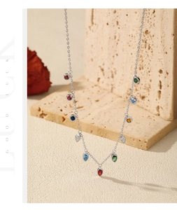 Detail view of S925 silver necklace with colorful gemstones on travertine stone display