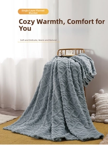 Close-up of gray-blue fleece blanket with textured geometric diamond weave on a chair