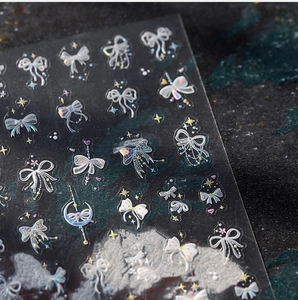 Détail de stickers à ongles holographiques noeuds et étoiles avec reflets arc-en-ciel