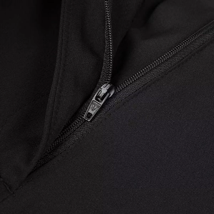 Detail of metal zipper head with triangle logo on black sleeveless top and pants set