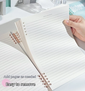 Close-up of refillable B5 notebook inner pages with horizontal lines and pre-punched holes