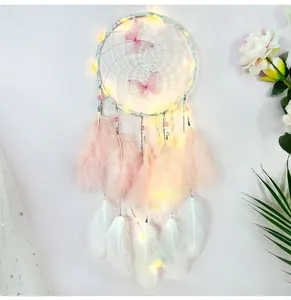 Detail of handmade butterfly dreamcatcher featuring LED lights and pink-white feathers