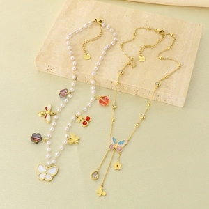 Detail of butterfly and pearl charm necklace with gold chain and zircon tassels