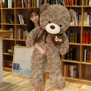 Macro detail of giant brown plush teddy bear with love heart and satin bow tie decor