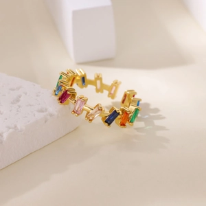 Detailed macro view of gold open ring featuring rainbow rectangular zircon stones set in brass