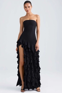 Détail d'une élégante robe de soirée noire bustier avec fente latérale et ourlet volanté