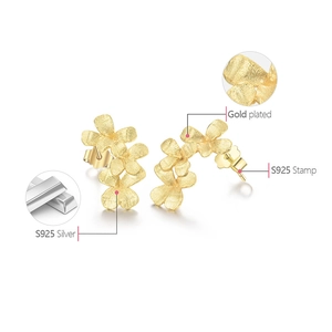Detailed macro view of S925 sterling silver gold-plated floral earrings with matte finish