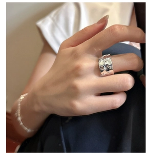 Detailed close-up of wide S925 sterling silver ring with irregular texture on hand