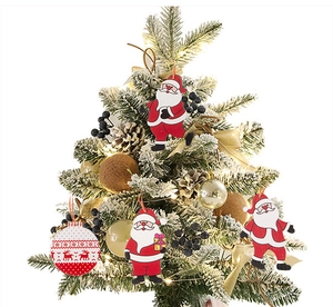 Close-up of wooden gnome and Santa ornaments hanging on a snowy Christmas tree branch