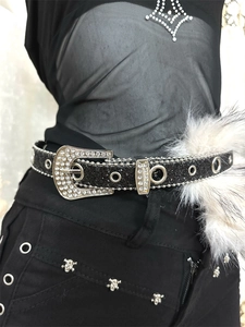 Gros plan sur une ceinture noire pailletée avec boucle en strass et œillets en métal