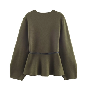 Detail of dark green peplum knit sweater with round neck and thin black waist belt