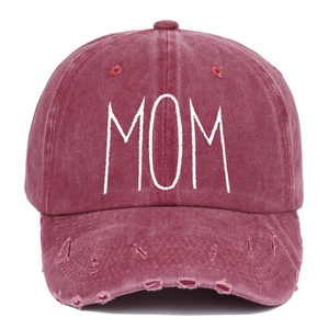 Dettaglio del ricamo MOM bianco su un berretto da baseball bordeaux effetto lavato