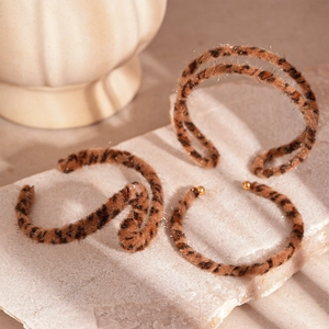 Retro leopard print flocking bangles with golden metal caps on marble display