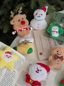 Detail view of assorted Christmas plush charms including Santa, Reindeer and Gingerbread Man