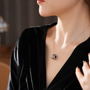 Primo piano di una collana in acciaio al titanio argento con ciondolo ad anello di zirconi
