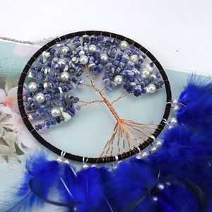 Detail of tree of life dreamcatcher with blue crystals, copper wire and soft feathers