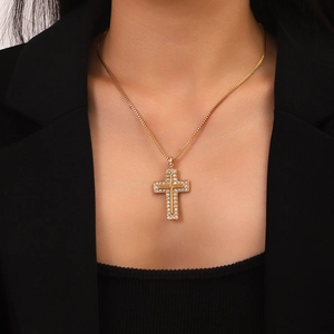 Close-up of a 18K gold box chain necklace with a crystal-encrusted double cross pendant