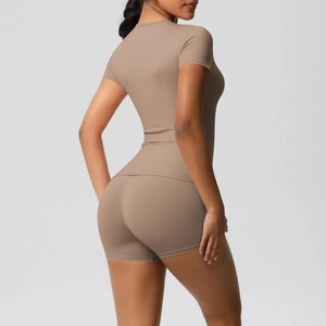 Close-up of moisture-wicking stretch fabric on slim-fit yoga top and high-waisted shorts
