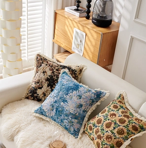 Details von Vintage-Jacquard-Kissen mit Blumenmuster und Fransen auf einem weißen Sofa