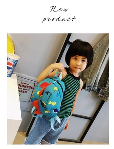 Blue toddler backpack with colorful dinosaur patterns shown on a girl model