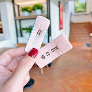 Detail showing front felt texture and back metal clip of a rectangular hair clip