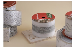 Close-up of silver Christmas ribbons with glitter patterns and vintage prints on rolls