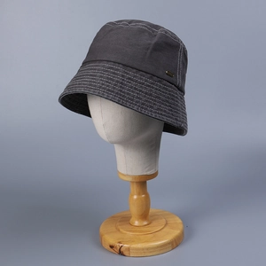 Detailed view of dark grey washed cotton bucket hat with white contrast stitching and metal tag
