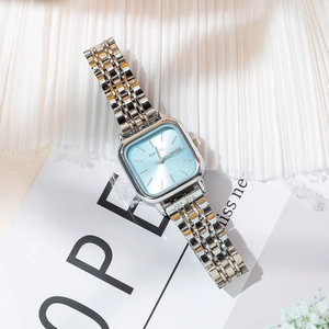 Detail of silver steel mesh strap and minimalist light blue square dial of women's watch