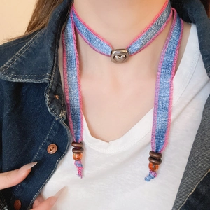 Detailed close-up of a blue denim heart choker with pink stitching and metal slider