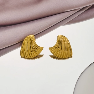 Golden fan-shaped wave earrings with polished finish on white reflective surface