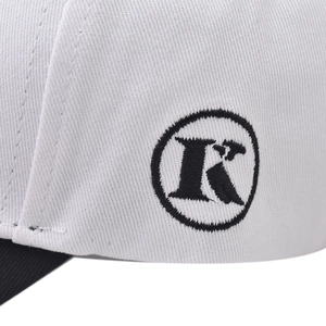 Detail view of cotton baseball cap with embroidered letter R logo and contrast stitching