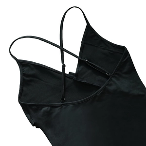 Détails des bretelles croisées réglables et boucles métalliques sur une robe noire