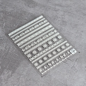 Detailed 5D embossed nail stickers featuring white snowflake and winter sweater patterns