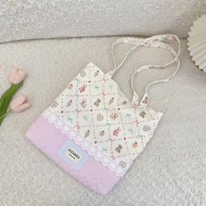 Close-up of pink heart quilting and cute cartoon prints on white canvas tote bag