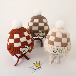 Gebreide babymuts met schaakbordpatroon, berenpatch en oorkleppen in bruine tinten