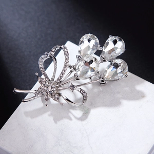 Macro view of silver floral brooch featuring teardrop crystals and sparkling rhinestones