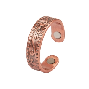 Detail of red copper magnetic ring featuring vintage embossed vine patterns and inner magnets