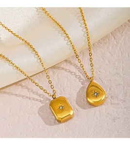 Macro detail of gold geometric pendants with starburst diamond patterns on silk fabric