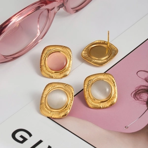 Vintage gold square rib earrings with cat-eye opal stones shown on a pink fashion magazine