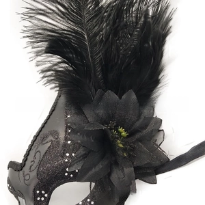 Dettaglio della maschera veneziana nera con piume, fiore a rete e perline decorative