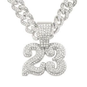 Macro detail of silver iced-out number 23 pendant with cubic zirconia on Cuban link chain