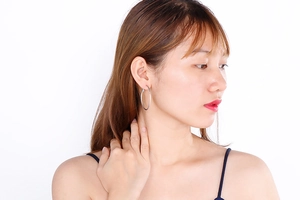 Side view of a large silver hoop earring worn by a model for a stylish minimalist look