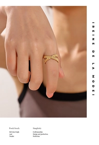Detail of 18K gold plated X-shaped cross ring featuring intricate bead texture on model