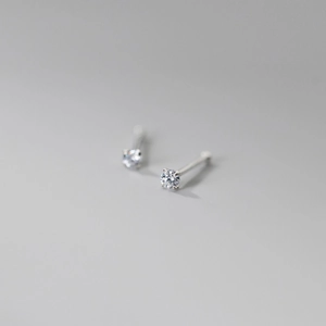 Macro shot of 999 sterling silver four-prong stud earrings with brilliant round zircon