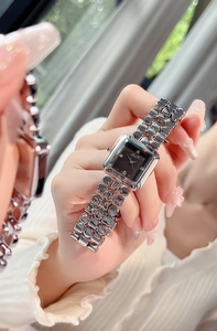 Detail of square black dial ladies watch with diamond markers and silver metal link strap