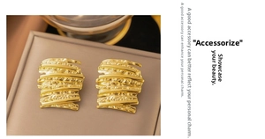 Detail view of irregular 18k gold hammered earrings with brushed metal texture